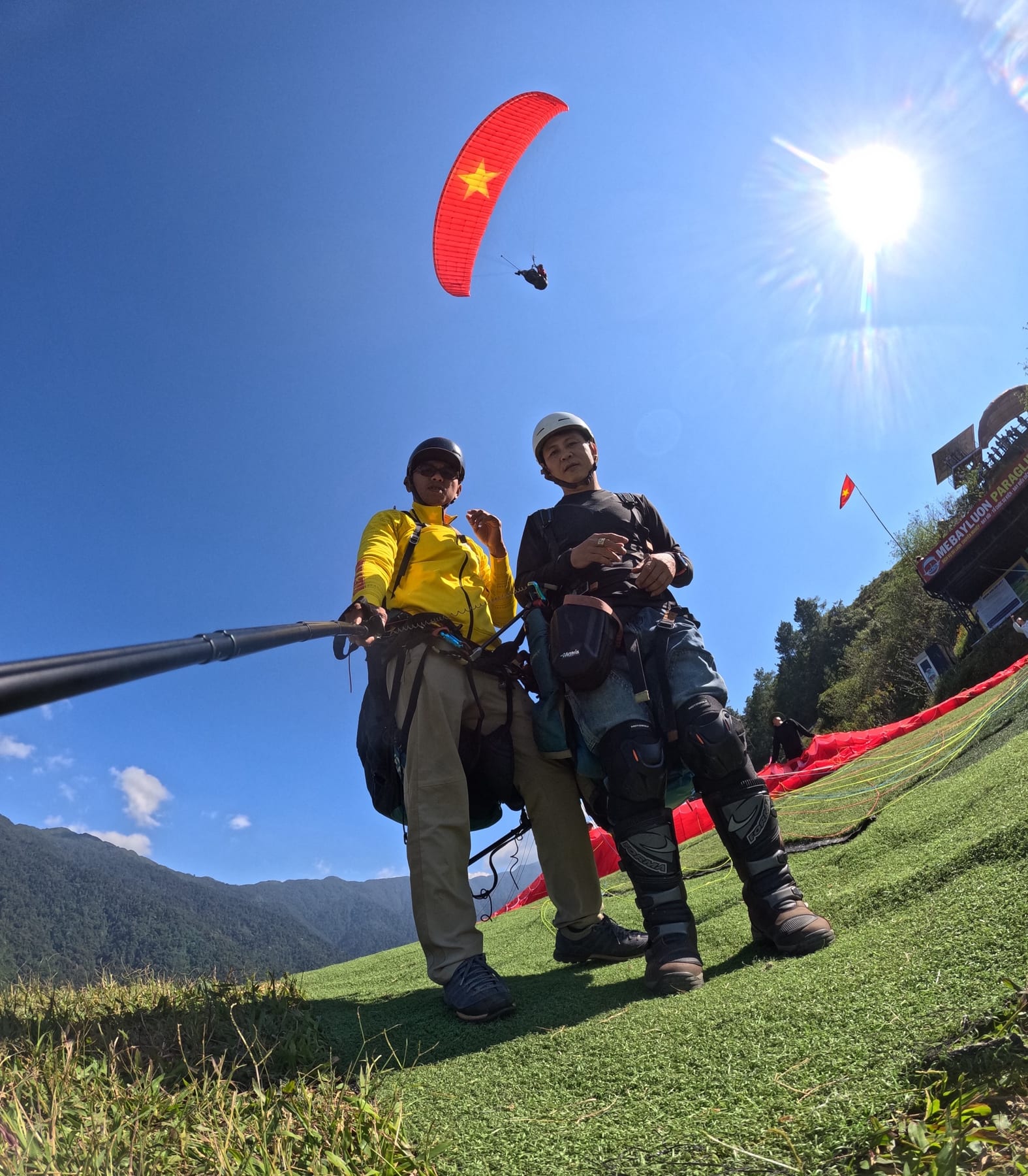 GoPro on the selfie stick: guest and pilot right at the launch, the red-flag wing overhead — this camera is free on every flight