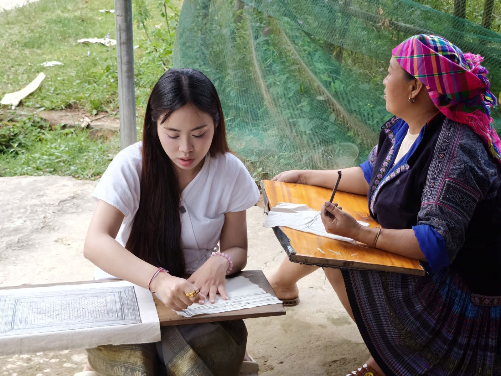 Drawing beeswax patterns on cloth with a Hmong woman in Lìm Mông village