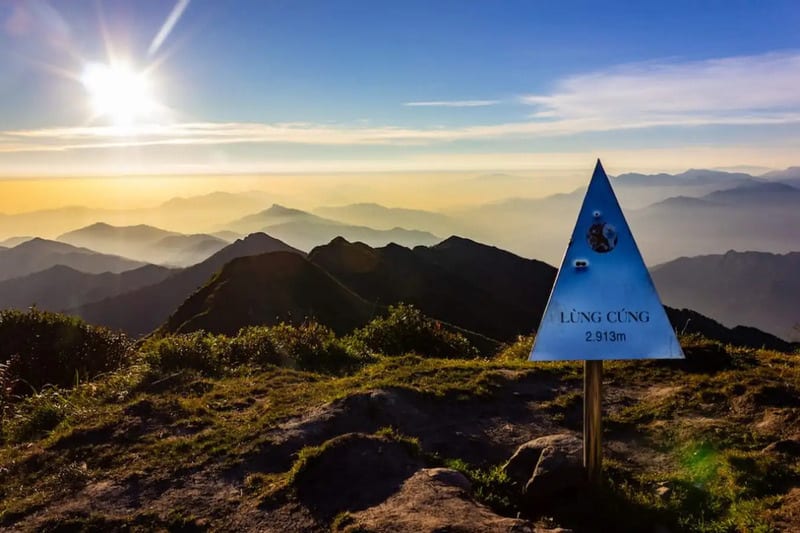 The 2,913 m summit marker of Lùng Cúng in early morning sun