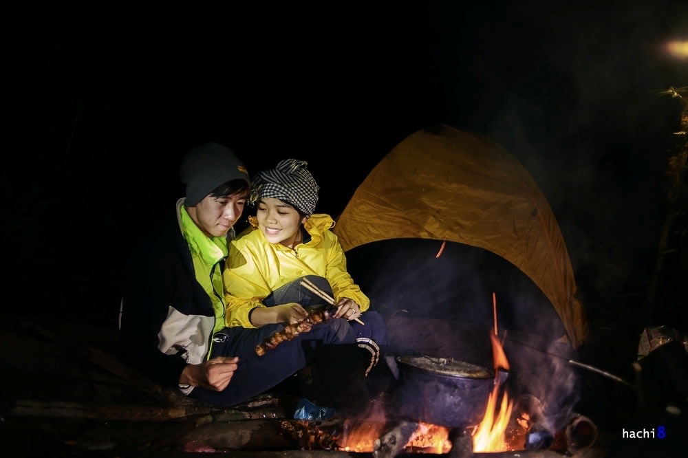Trekkers camping and cooking over a fire in the Lùng Cúng forest