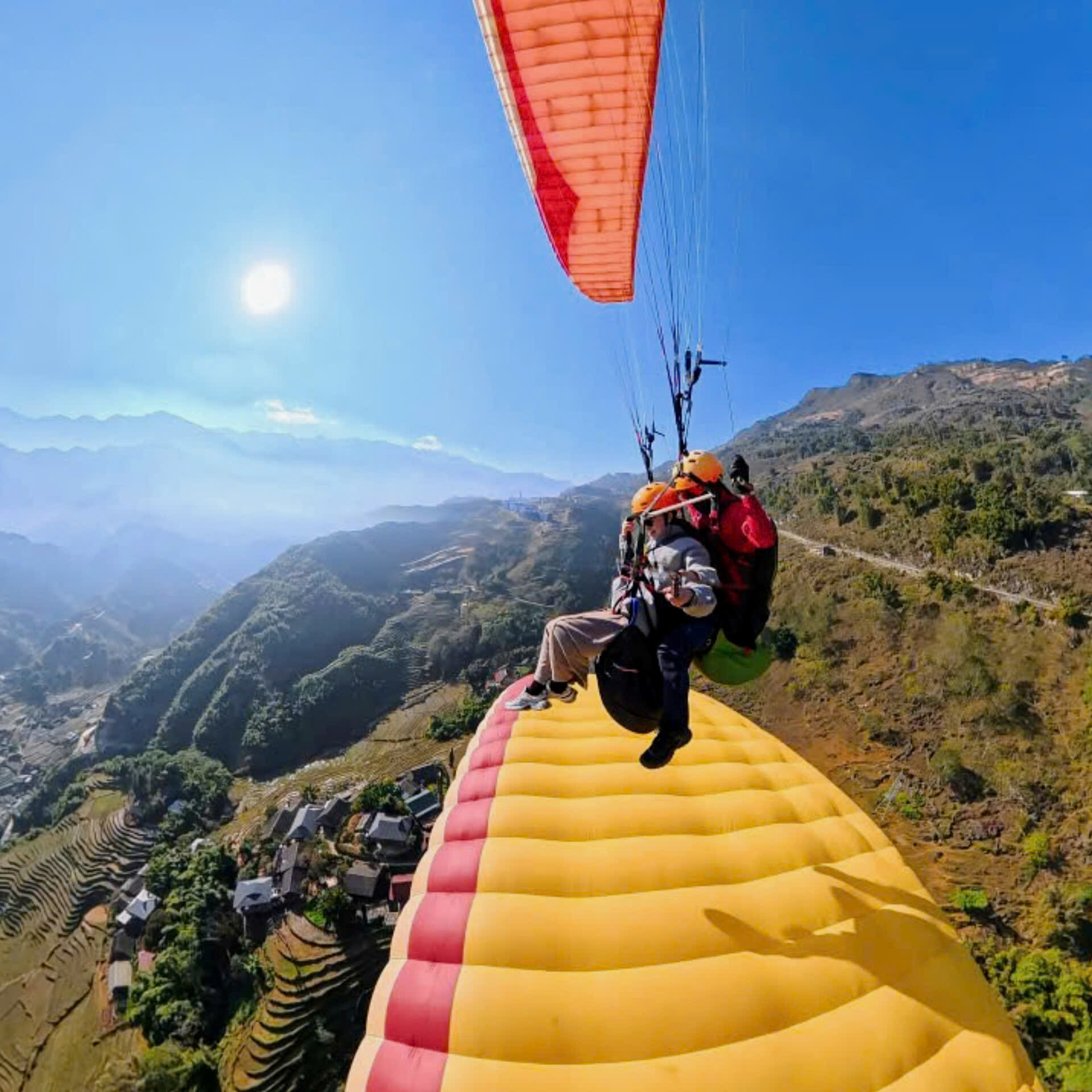 Two paragliders flying together over Sapa