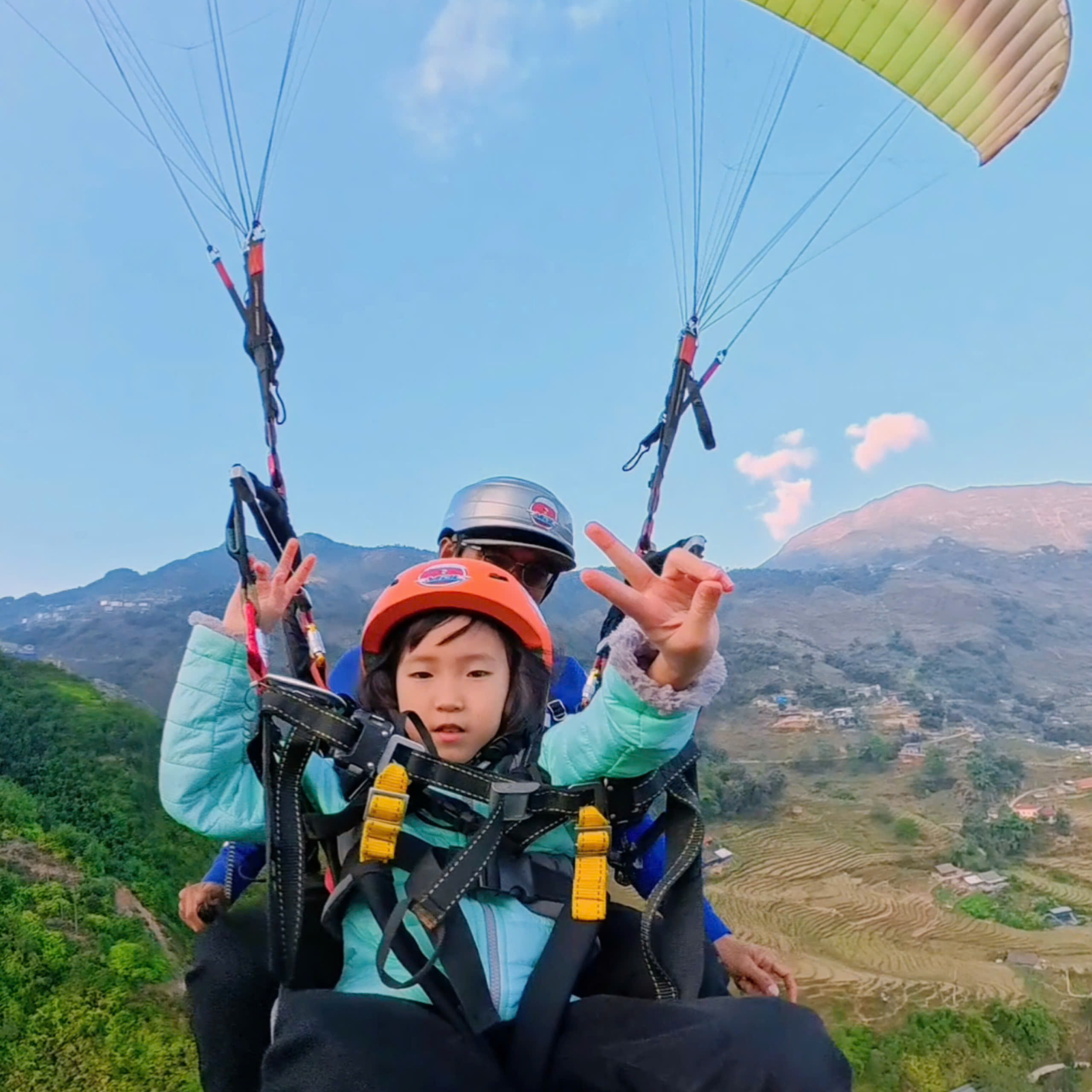 A child from Singapore on a tandem paragliding flight in Sapa