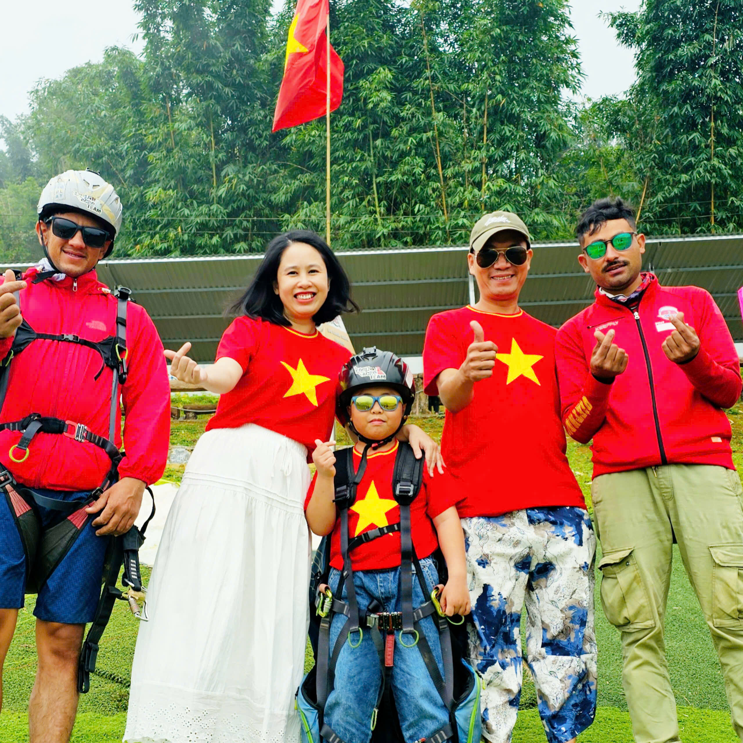 A family photographed with their paragliding pilot in Sapa