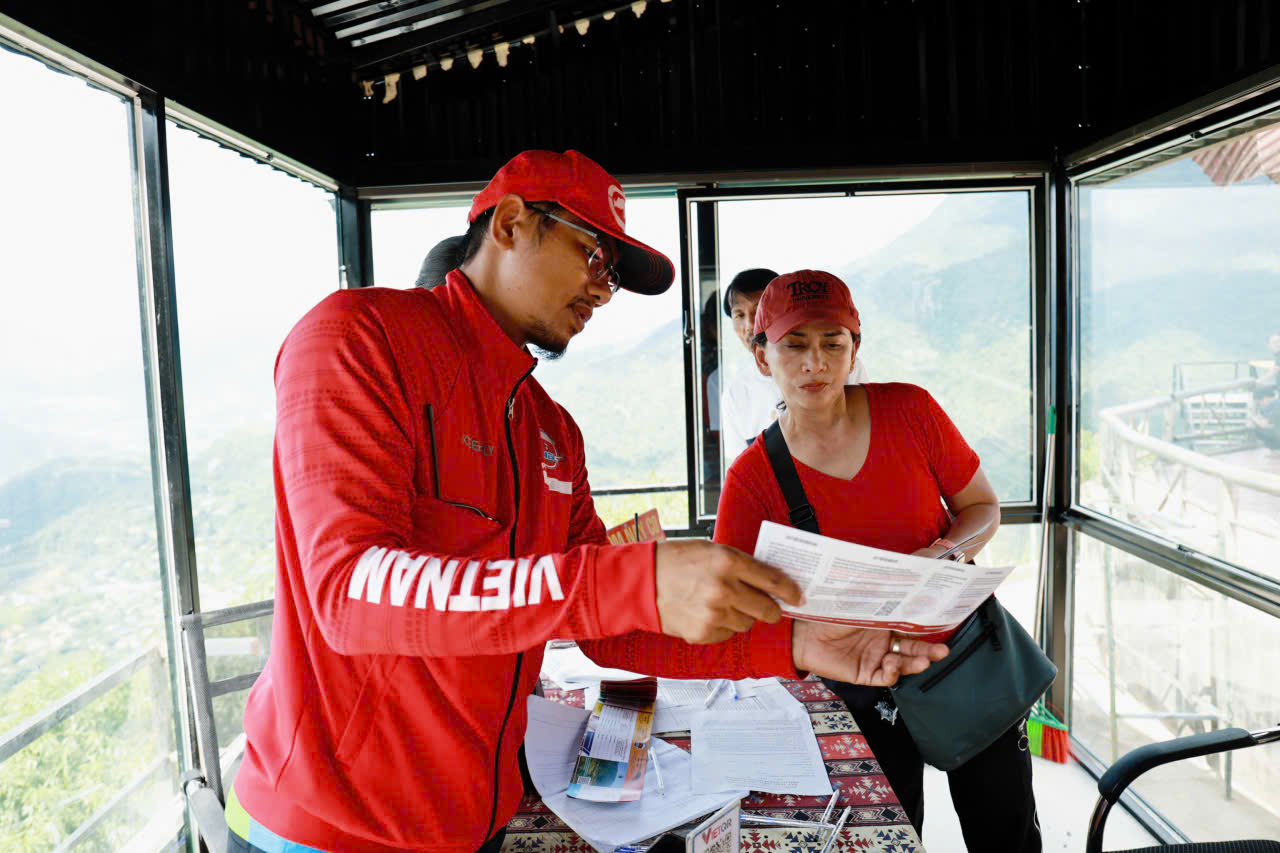 Pilot Dang Van My explaining the safety of the paragliding equipment