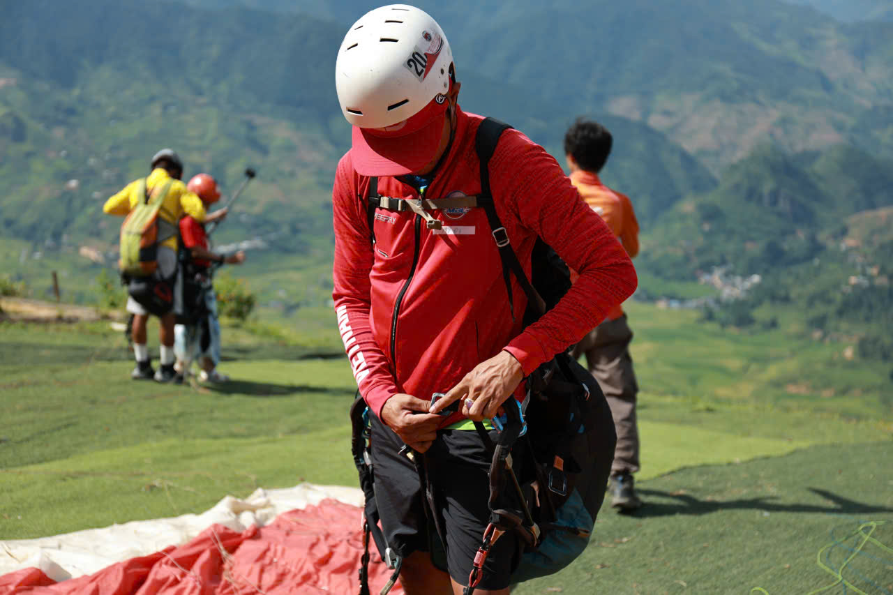 Checking the harness and connection points before a paragliding flight