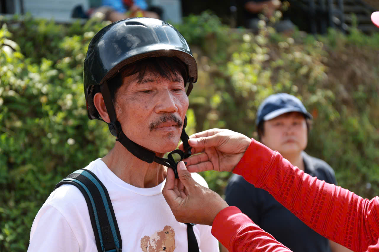 A passenger being fitted with a helmet before the flight