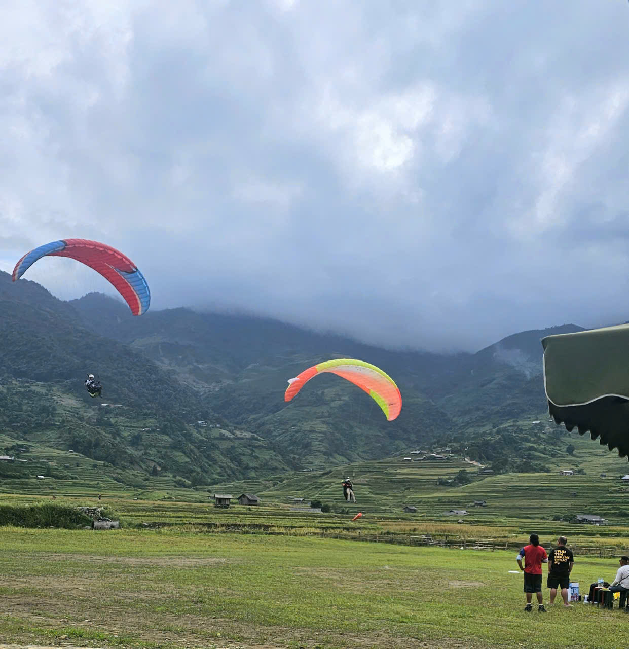 Two paragliders on approach to land in Mu Cang Chai
