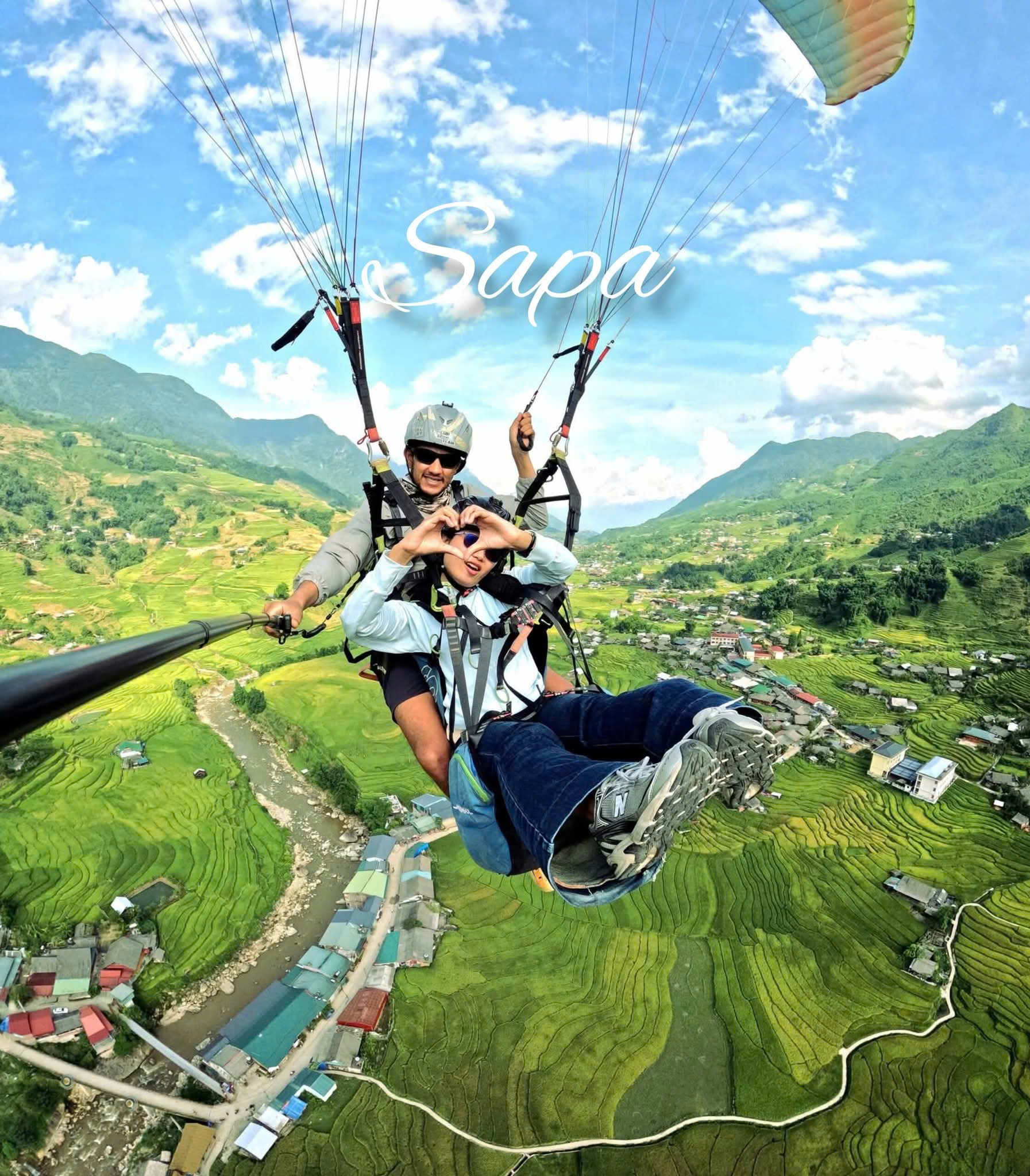 Muong Hoa valley seen from a paraglider — terraced fields running down the slopes below the Hoang Lien Son range.
