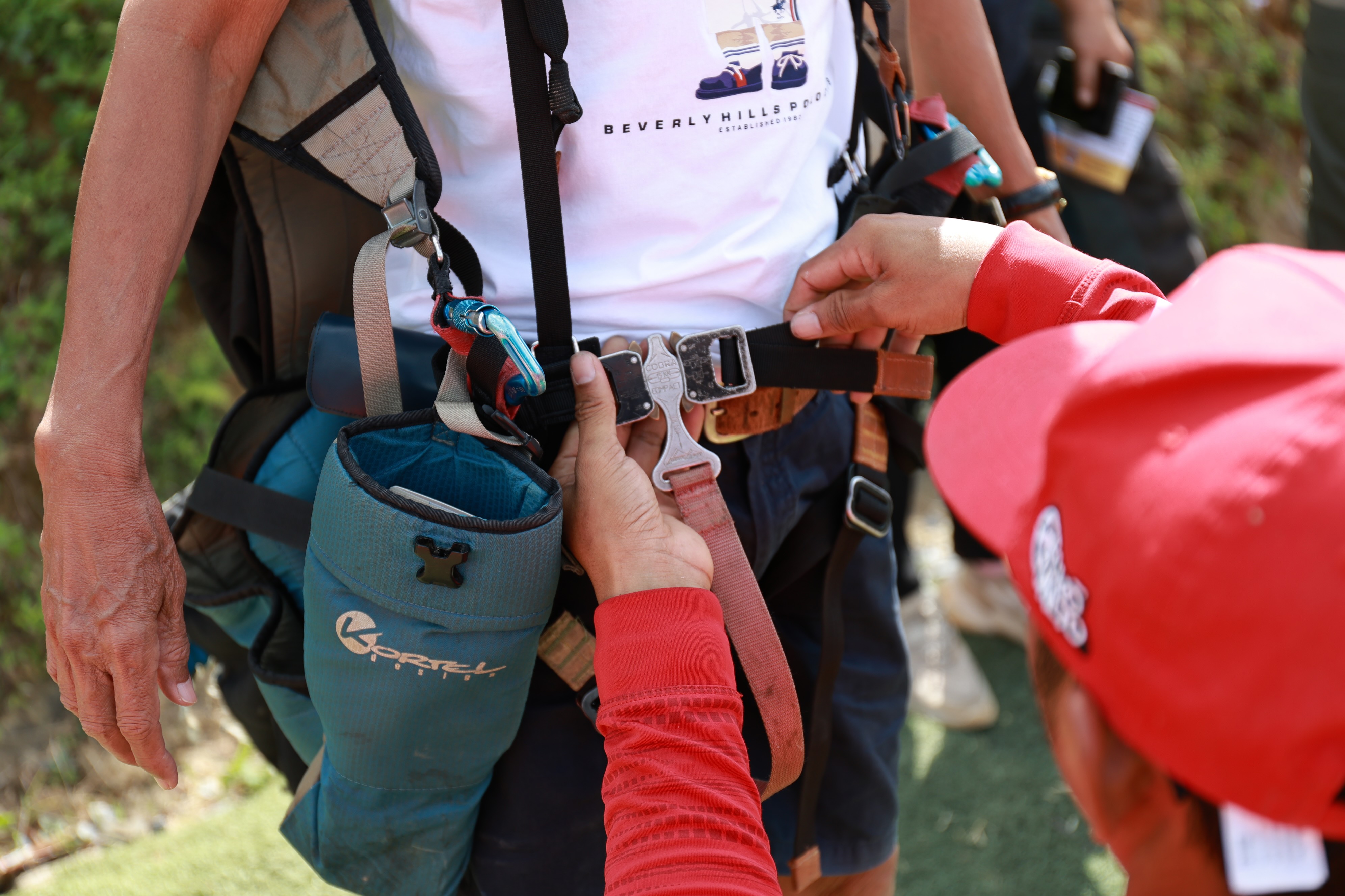 The pilot fastens the passenger's harness himself and checks it carefully.