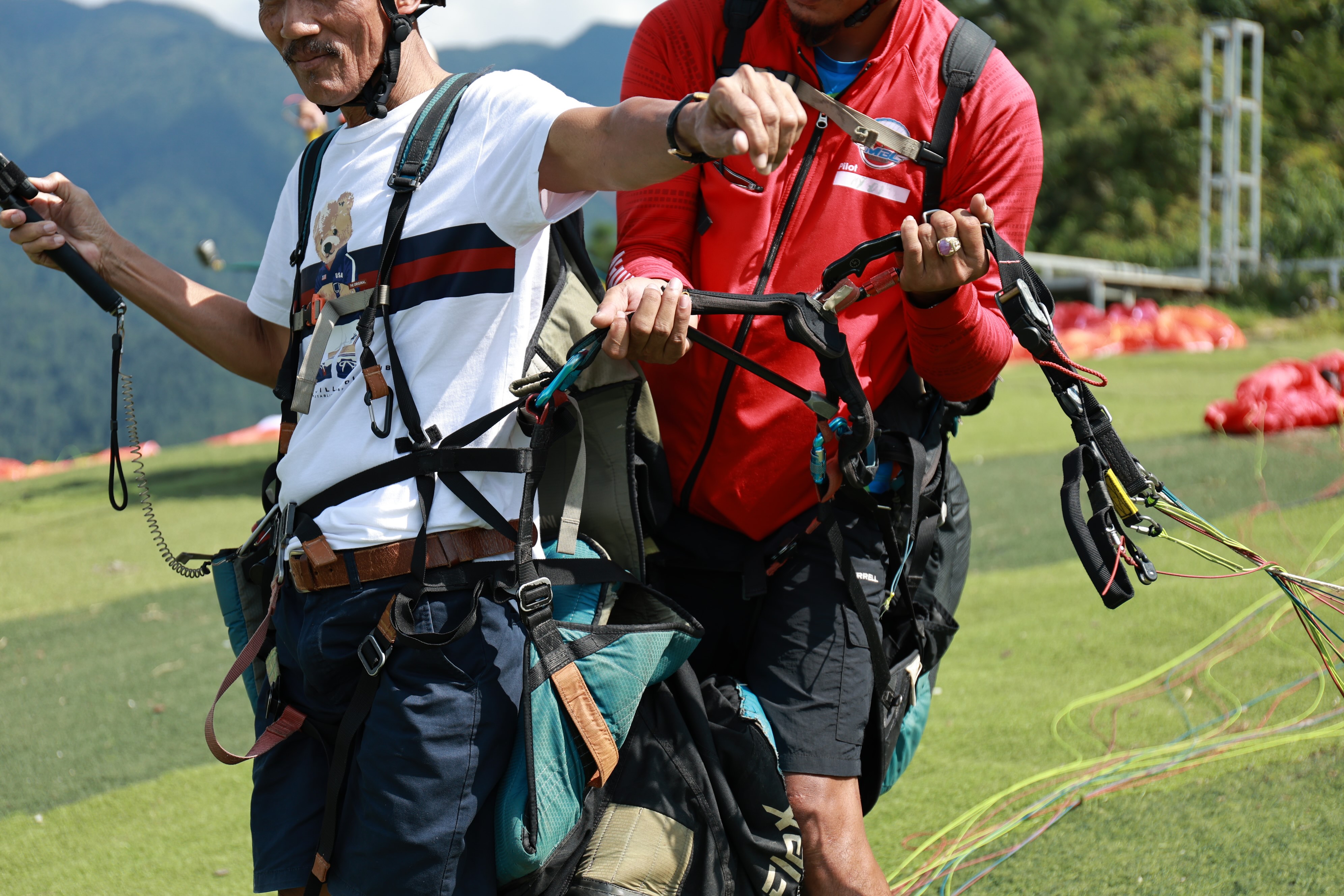 Pilot and passenger are connected together — and the connection points are checked before flying.