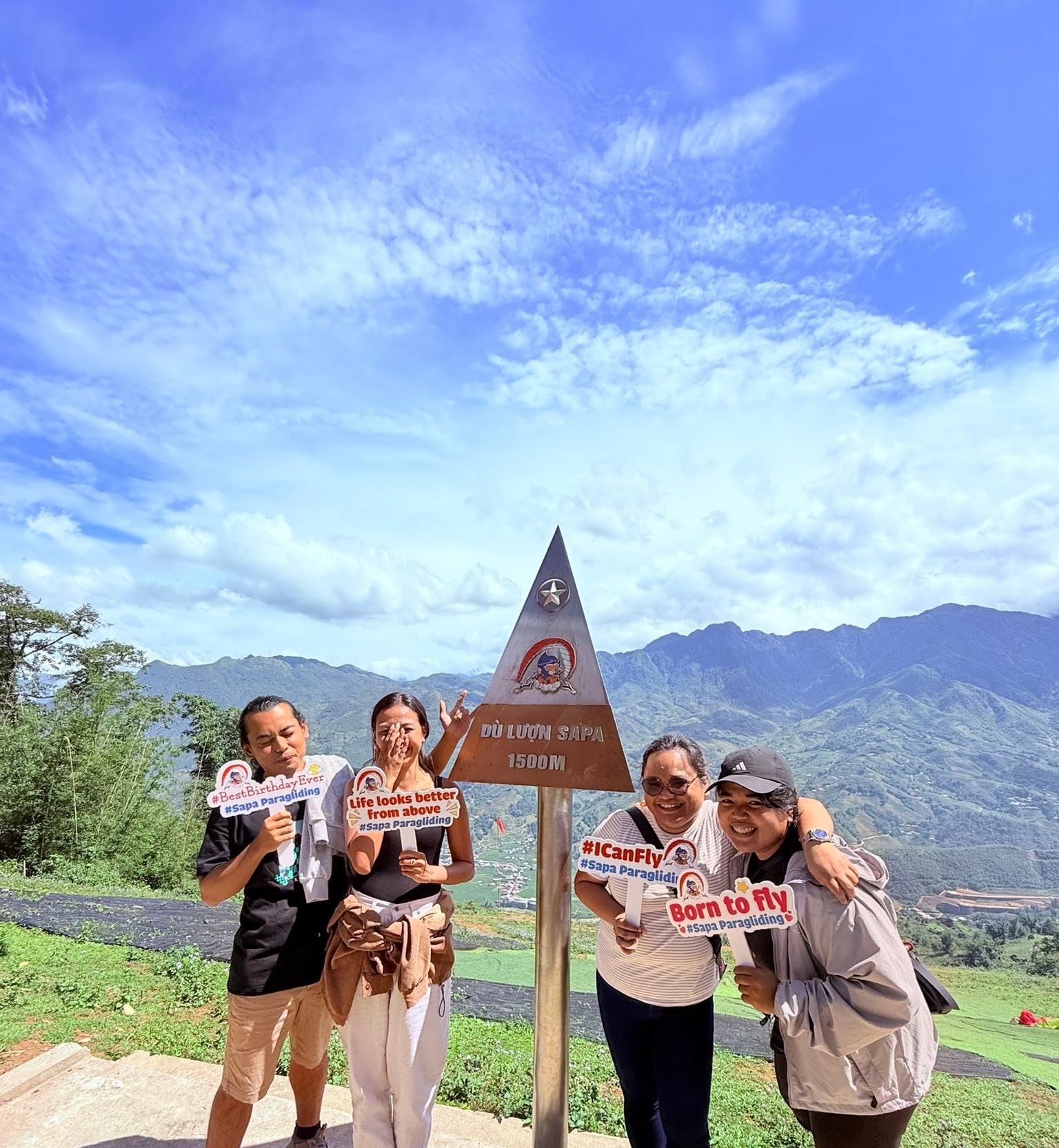 Visitors posing at the Sapa Paragliding 1500m landmark sign