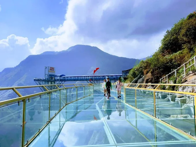 Tourists walking on the Rong May Glass Bridge above O Quy Ho Pass