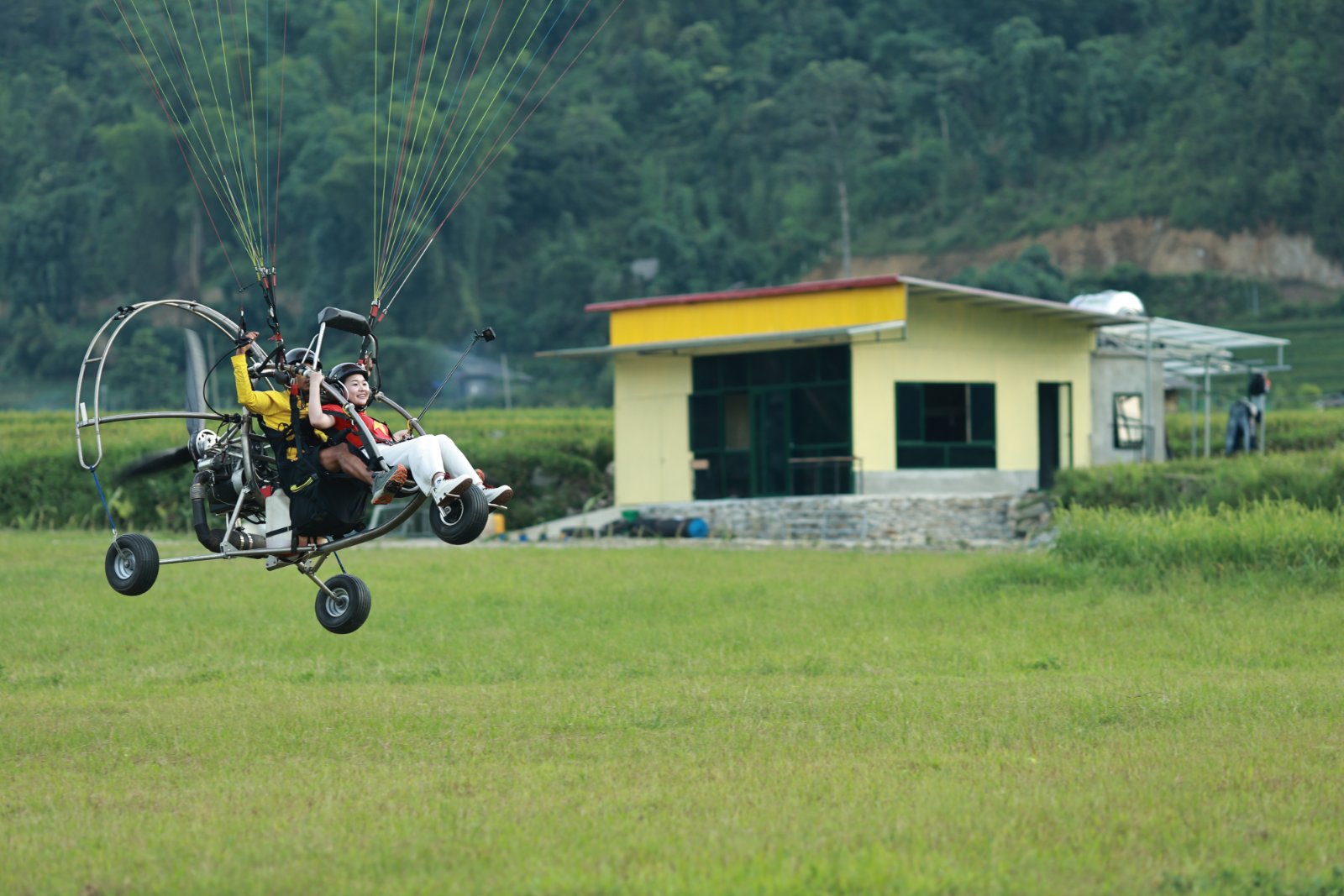 Wheels leaving the ground — the launch moment of a powered paragliding flight in Mu Cang Chai