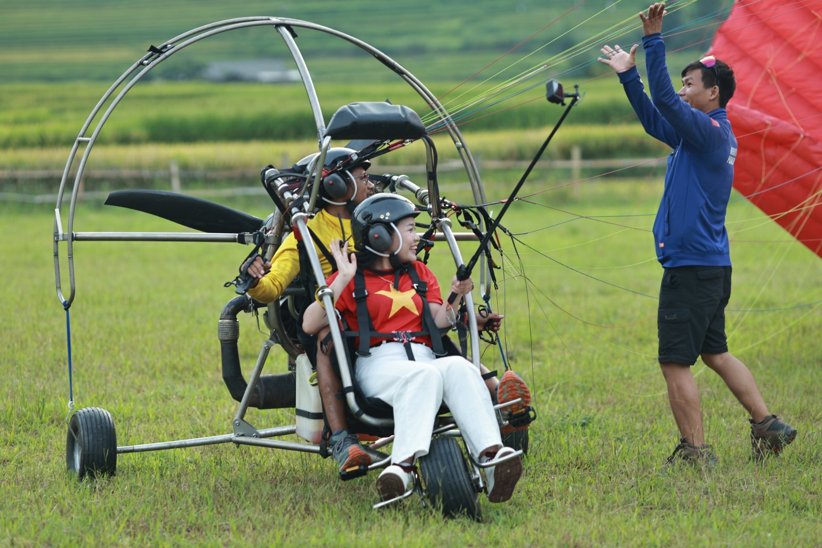 Landing on the flat field, with the ground crew waiting to gather the wing