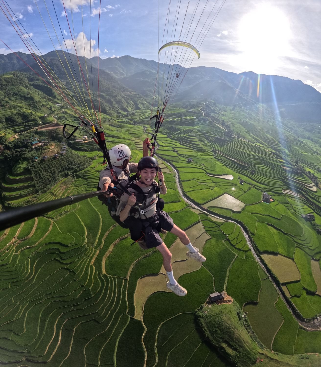 Bay dù lượn đôi tại Mù Cang Chải — ruộng bậc thang xanh ngút ngàn, trong khung hình gần như không có công trình
