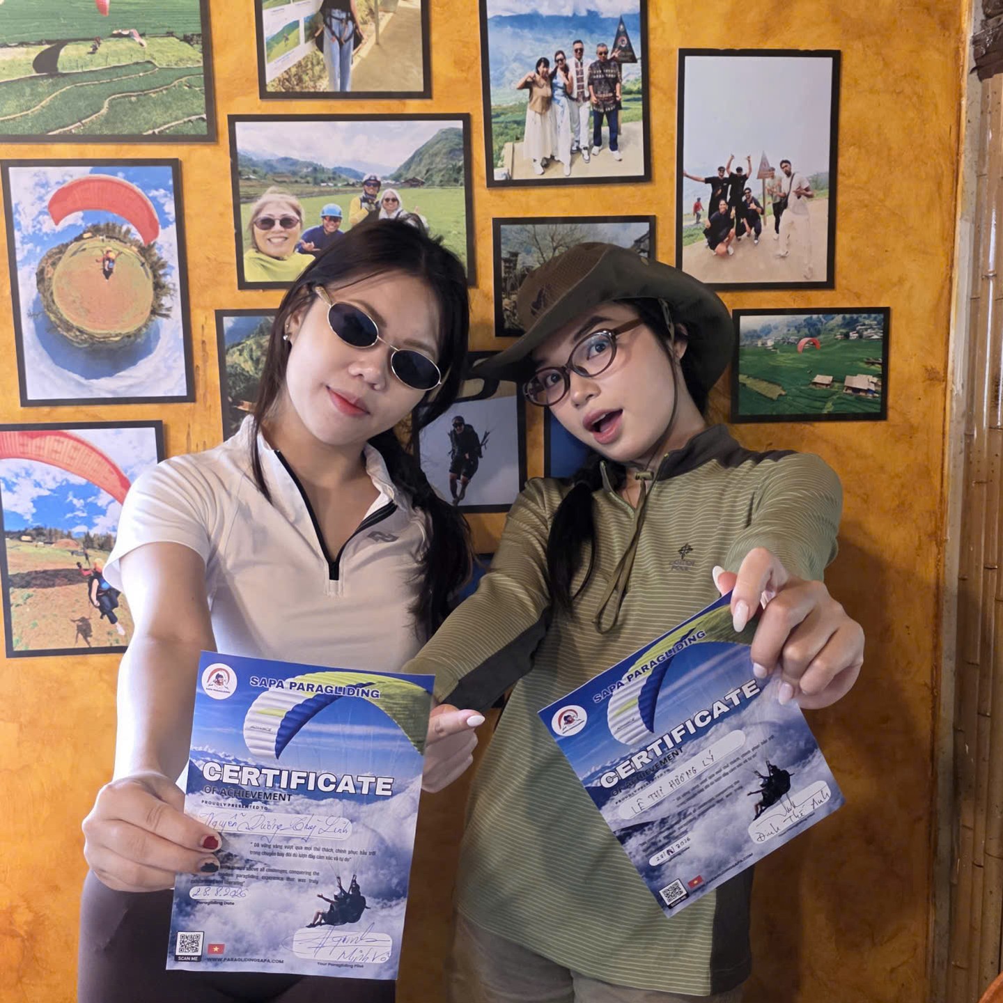 Passengers holding their Sapa Paragliding flight certificates at the clubhouse