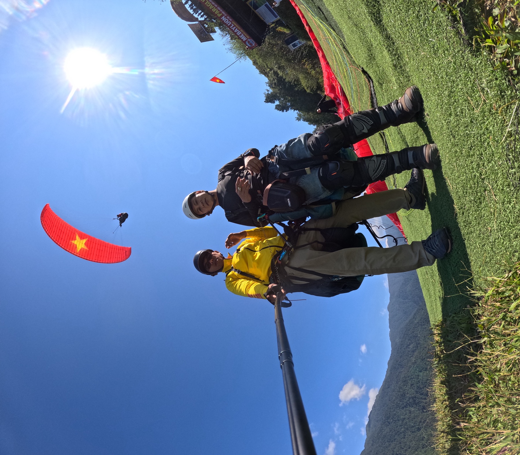 GoPro on the selfie stick: guest and pilot right at the launch, the red-flag wing overhead — this camera is free on every flight