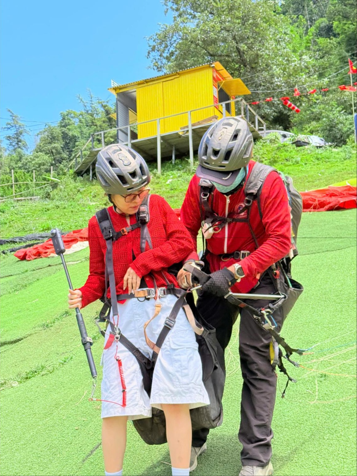 Phi công bay đôi và khách đeo đai an toàn, đội mũ bảo hiểm trên bãi cất cánh Sa Pa