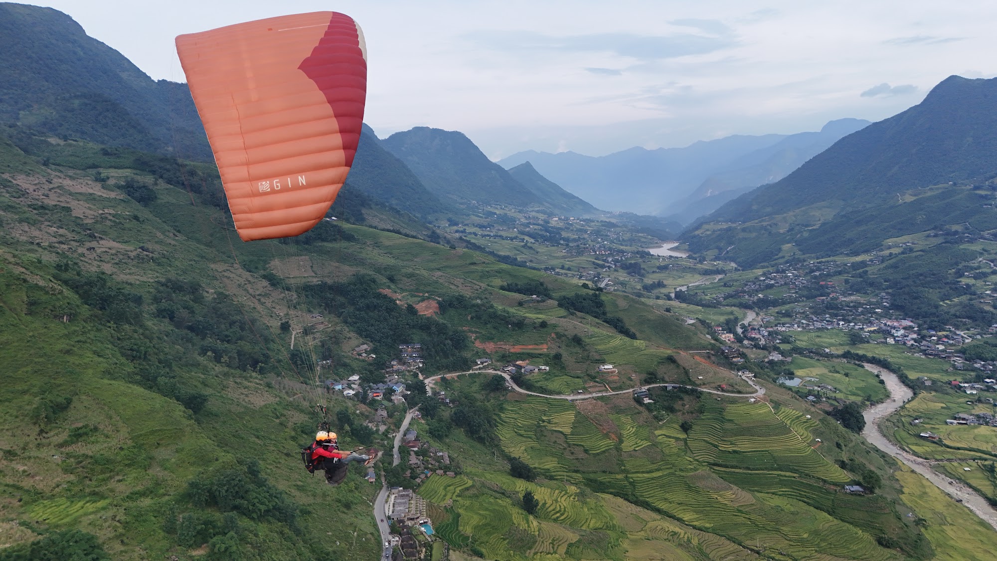 Muong Hoa Valley seen from under a paraglider wing, far ridges in mist
