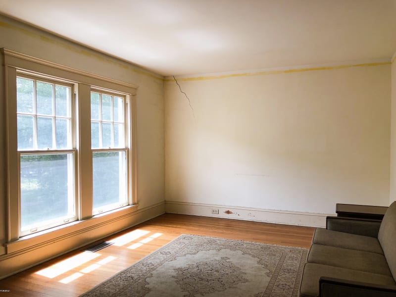 Arlington colonial home living room with yellowed original paint before repainting