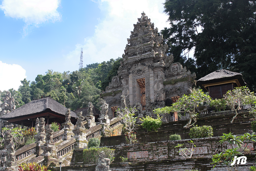 View of the majestic stone steps leading up to Pura Kehen in Bali, adorned with intricate carvings and surrounded by lush greenery, showcasing its historical and spiritual significance.