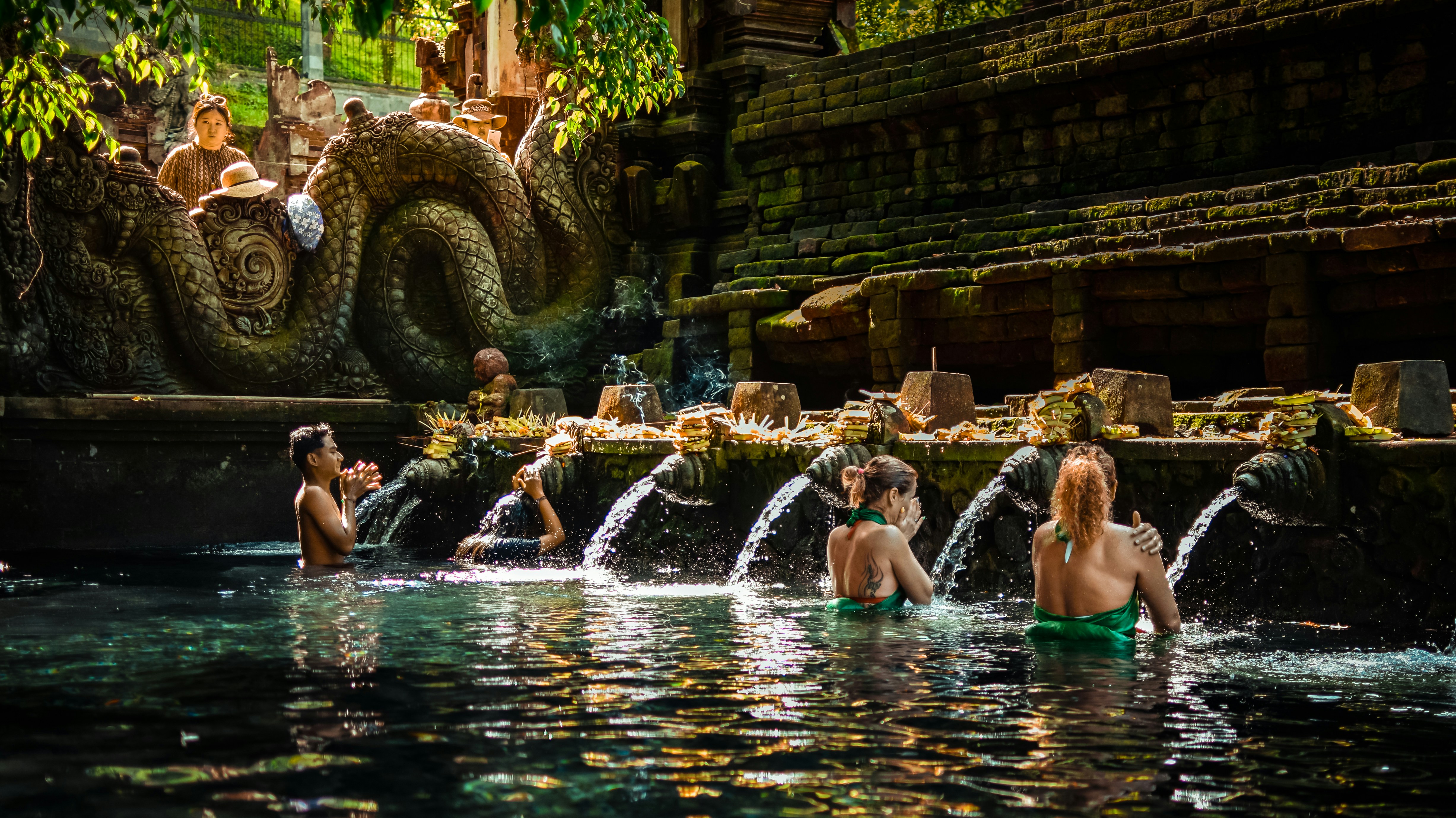 Visitors participating in a traditional cleansing ritual at the sacred Tirta Empul Temple in Bali.