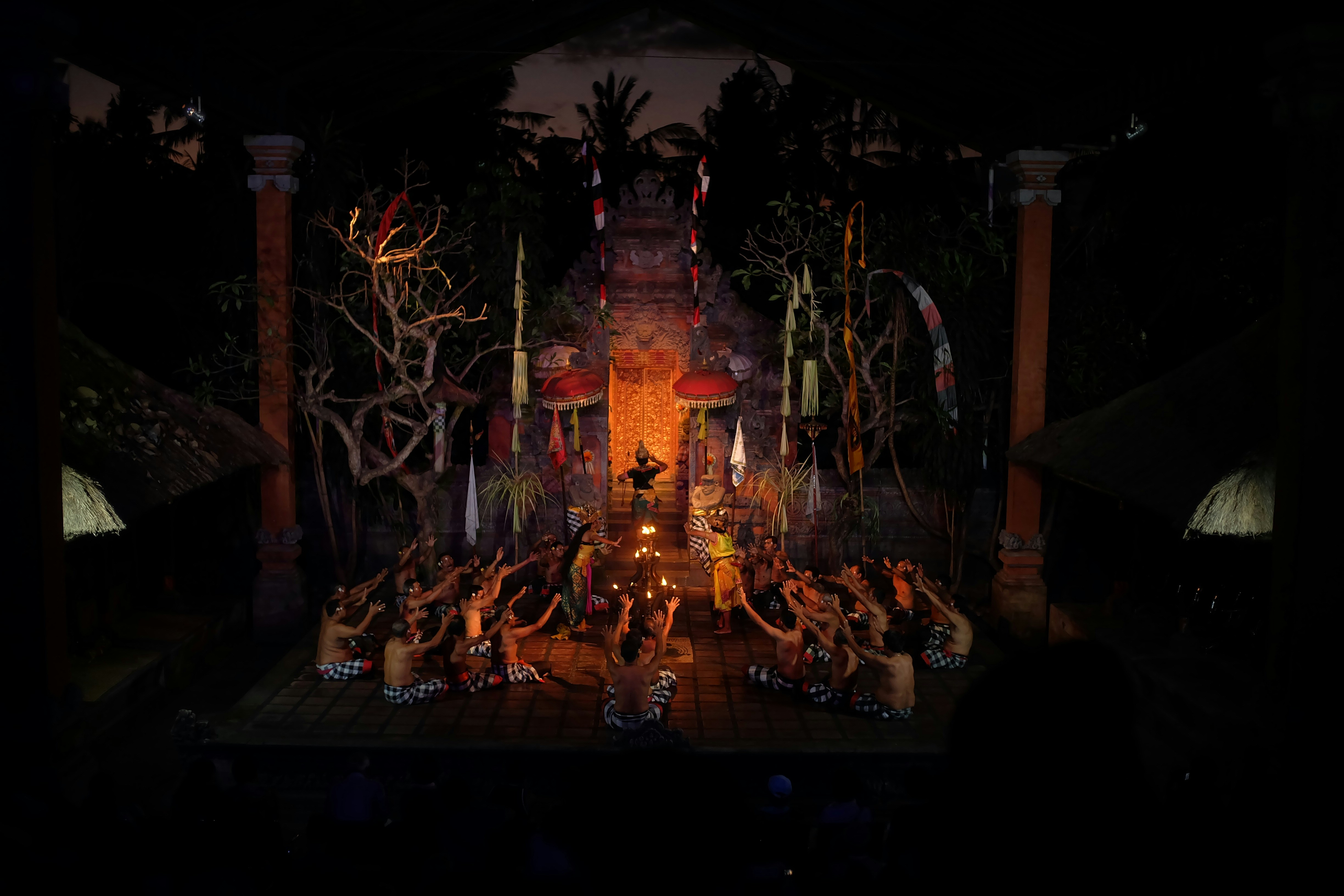 A mesmerizing Kecak dance performance set against a dramatic temple backdrop, with performers in traditional attire under the night sky.