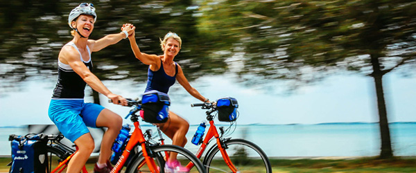 Due cicliste in viaggio con bici arancioni 