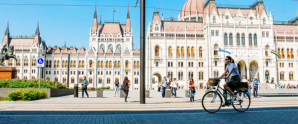 Radfahrer vor dem ungarischen Parlamentsgebäude in Budapest entlang der Donau. Radfahrer im Urlaub mit Girolibero.
