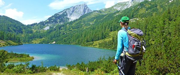 Escursionista che ammira il lago di Gosau, circondato da montagne nel Salzkammergut, Austria.