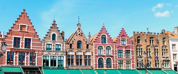 Storiche case colorate con tetti a gradoni nella piazza principale di Bruges, Fiandre