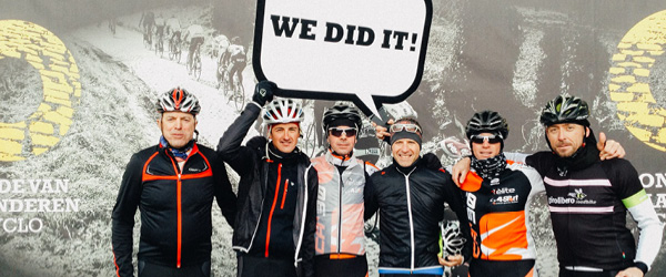 Gruppo di ciclisti che festeggiano con un cartello 