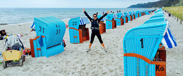 ciclista su una spiaggia del Mar Baltico circondato da cabine colorate