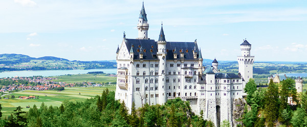 Castello di Neuschwanstein, Baviera, Germania, visto dalla Romantische Strasse, circondato da montagne e foreste.