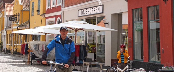Ciclista in una piazza con edifici storici e caffè all'aperto, isola di Fyn, Danimarca