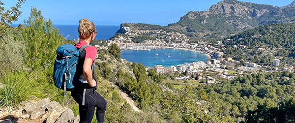 Escursionista che ammira il panorama di montagne e mare a Maiorca, Spagna, lungo un sentiero panoramico.