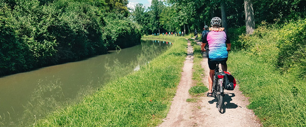 Gruppo in viaggio in bicicletta lungo un canale nella regione della Champagne, Francia, viaggi in bicicletta 