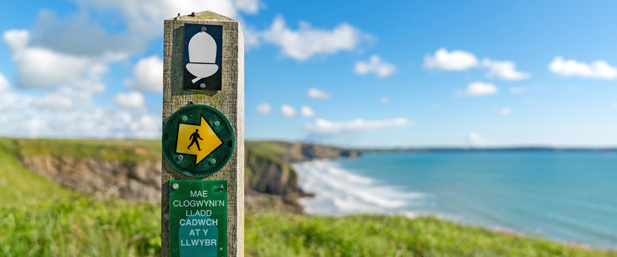 Segnaletica del Pembrokeshire Coast Path lungo la costa gallese, Galles sud-occidentale.