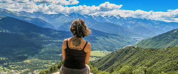Donna seduta su un belvedere con vista sulle montagne durante un viaggio in Georgia.