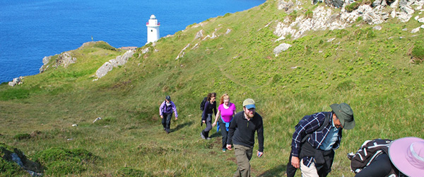Gruppo di escursionisti lungo un sentiero costiero con vista sul mare tra Cork e Kerry, viaggi a piedi 