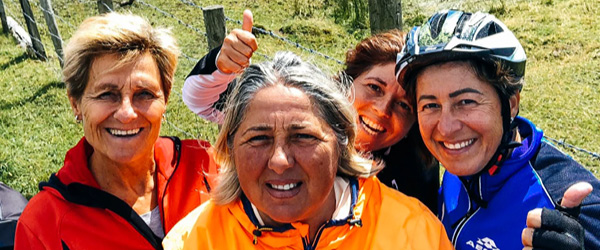 Gruppo di amici sorridenti in bicicletta tra i paesaggi verdi del Connemara, Irlanda in bici 