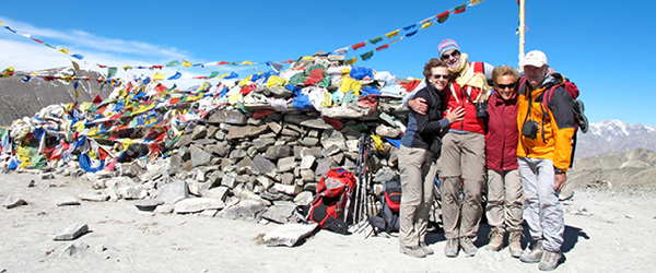 Escursionisti al passo Khardung La con bandiere di preghiera tibetane, nei pressi di Leh, Ladakh.