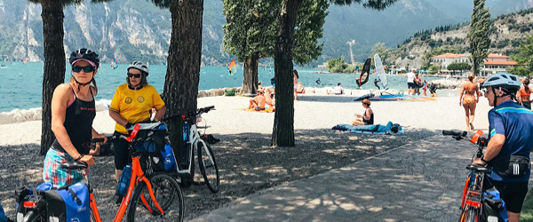Family cycling along the shores of Lake Garda, Italy.