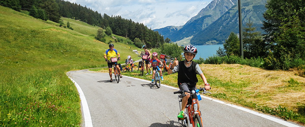 Familie auf dem Vinschgau-Radweg mit Blick auf die Südtiroler Berge.
