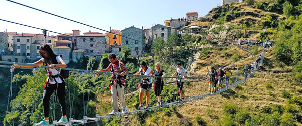 escursionisti percorrono ponte sospeso tra le colline lucane