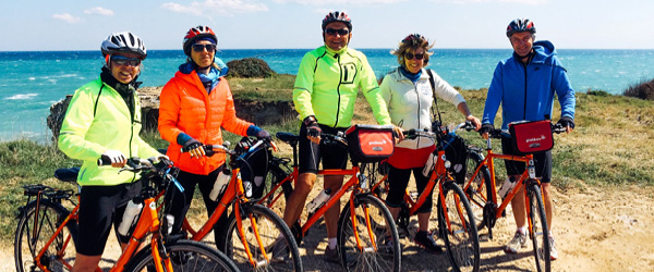 Gruppo di ciclisti durante un viaggio in Salento in bici con vista sul mare