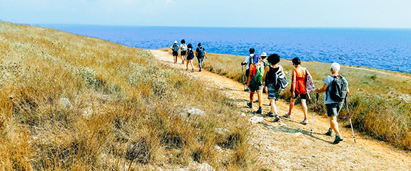 Escursionisti su un percorso costiero con vista mare nel Salento.