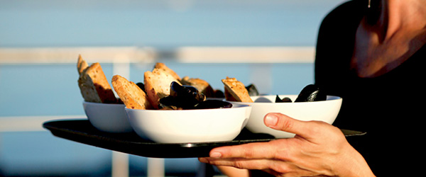 Cameriera che serve piatti su un vassoio, vacanze in barca 