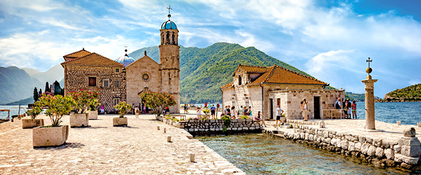 Città costiera di Budva con edifici storici e mare cristallino.