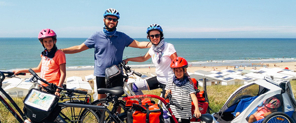 Famiglia in bici davanti alla costa con vista sul mare, Olanda in bici per famiglie